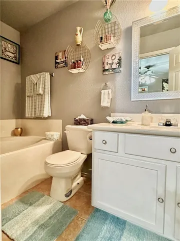 a bathroom with a granite countertop toilet sink and mirror