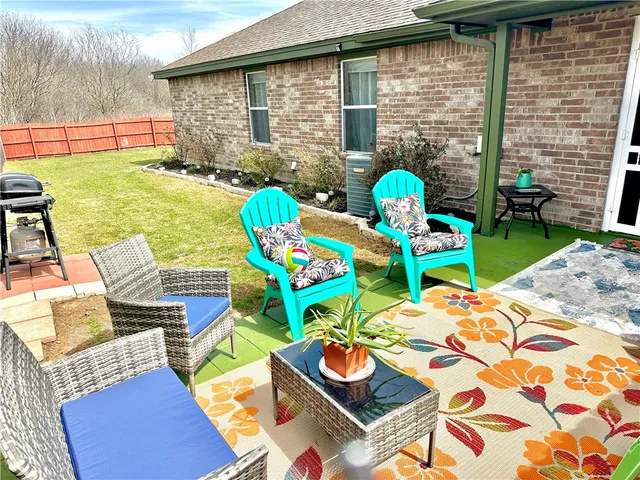 a view of a chairs and table in the backyard