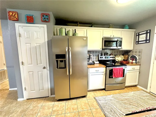a kitchen with stainless steel appliances granite countertop a refrigerator and a stove top oven