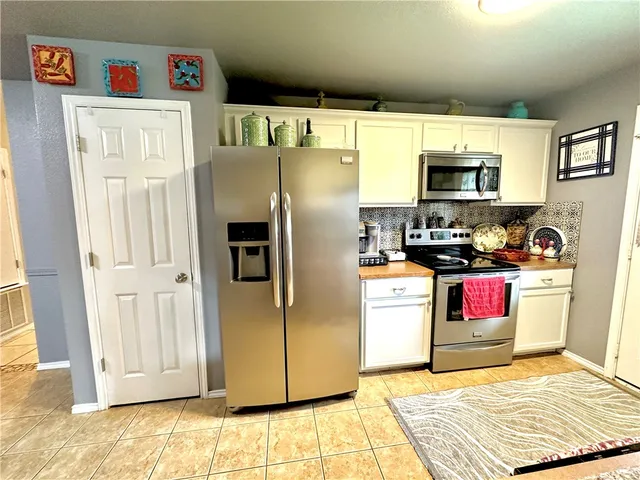 a kitchen with stainless steel appliances granite countertop a refrigerator and a stove top oven