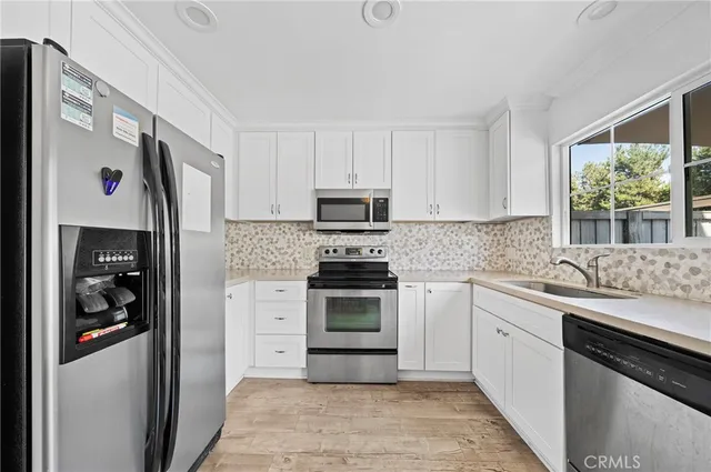a kitchen with stainless steel appliances granite countertop a refrigerator sink and stove