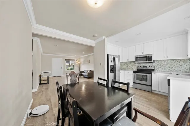 a kitchen with stainless steel appliances granite countertop a stove a refrigerator a kitchen island a table and chairs
