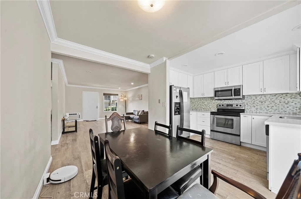 63 Streamwood Irvine, CA 92620 - Photo 13 of 25 a kitchen with stainless steel appliances granite countertop a stove a refrigerator a kitchen island a table and chairs