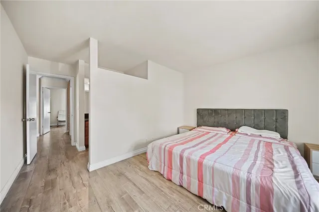 a bedroom with a bed and wooden floor