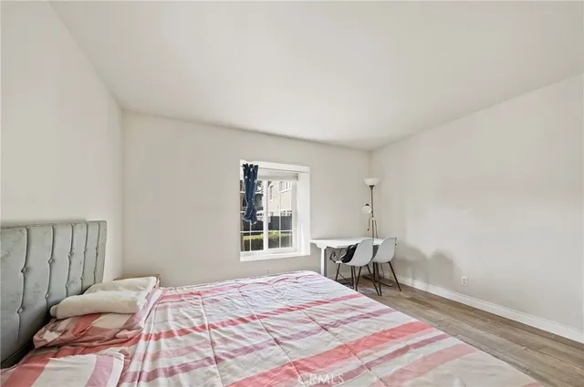 a bed sitting in a bedroom next to a window and chair