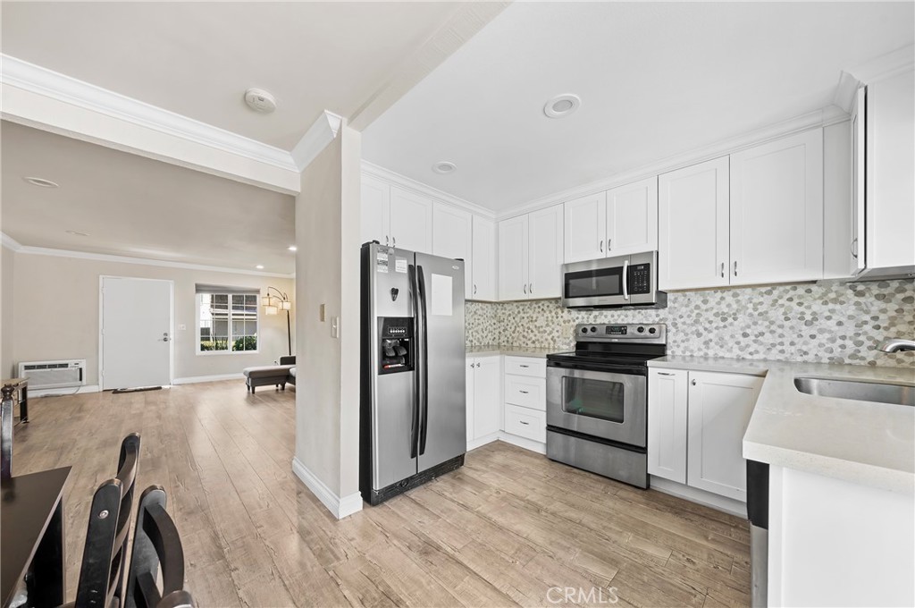 63 Streamwood Irvine, CA 92620 - Photo 9 of 25 a kitchen with stainless steel appliances a refrigerator stove and sink