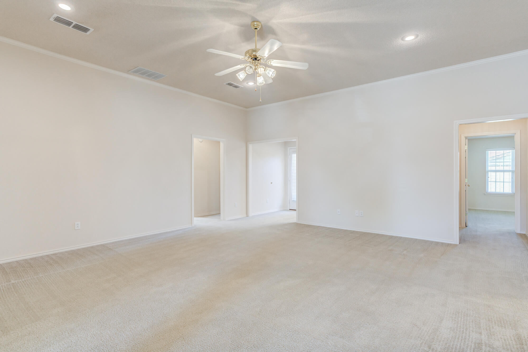 5914 88th Place Lubbock, TX 79424 - Photo 14 of 39 an empty room with a chandelier fan and windows