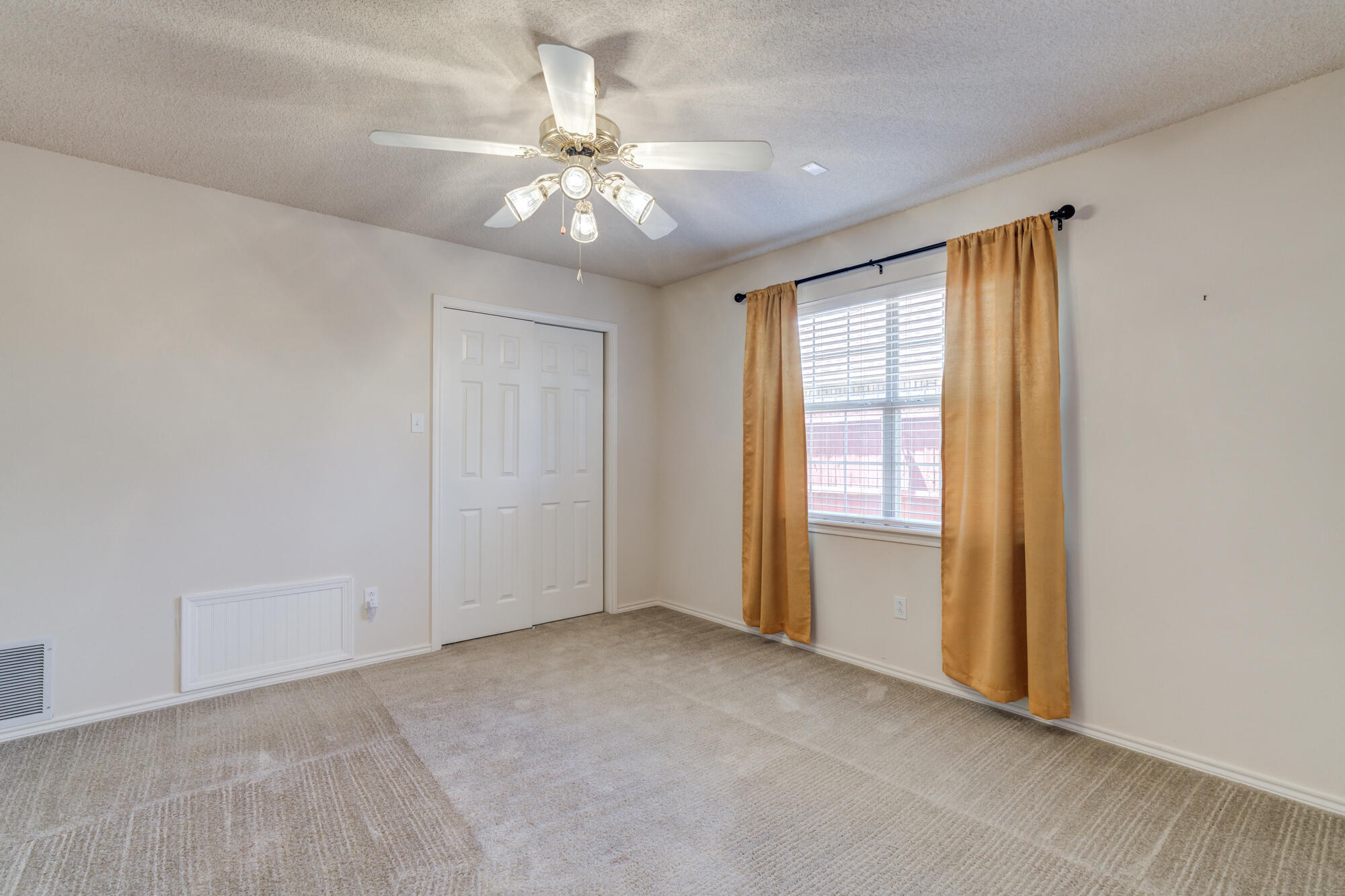 5914 88th Place Lubbock, TX 79424 - Photo 29 of 39 an empty room with chandelier fan and windows