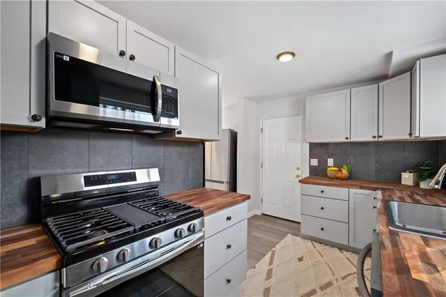 a kitchen with stainless steel appliances a sink a stove and microwave