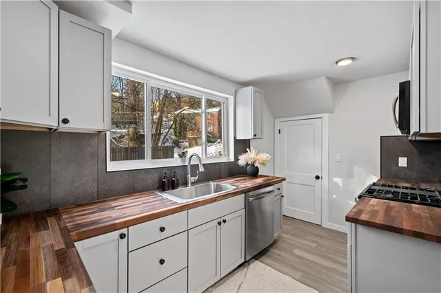 a kitchen with stainless steel appliances granite countertop a sink stove and cabinets