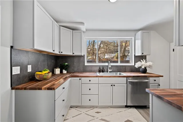 a kitchen with stainless steel appliances granite countertop a sink a stove and a window