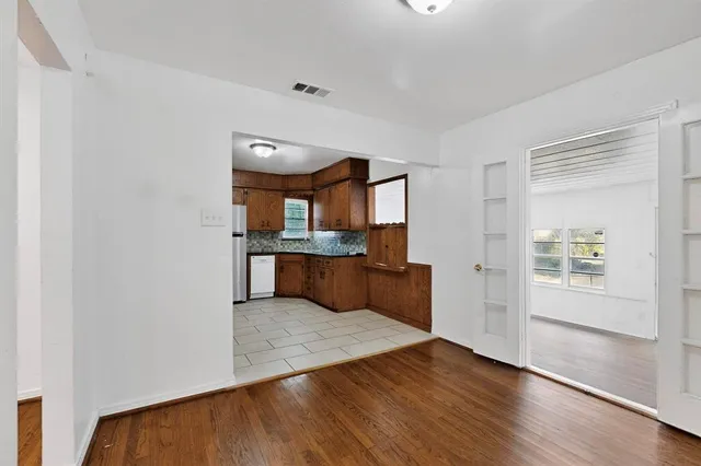 a large kitchen with wooden floor and a window
