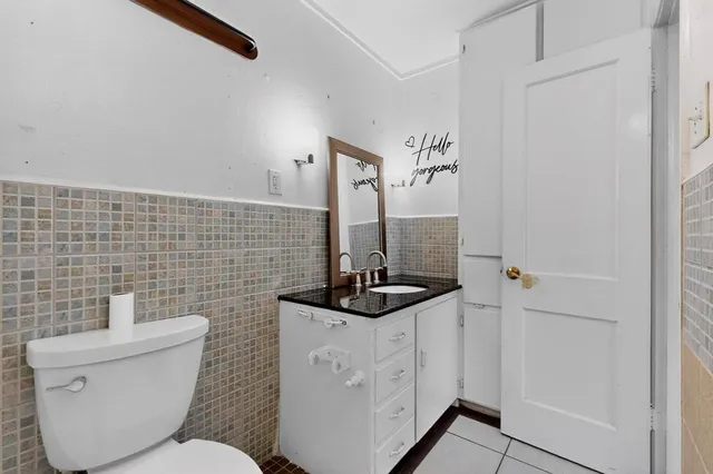 a bathroom with a toilet a sink and a mirror