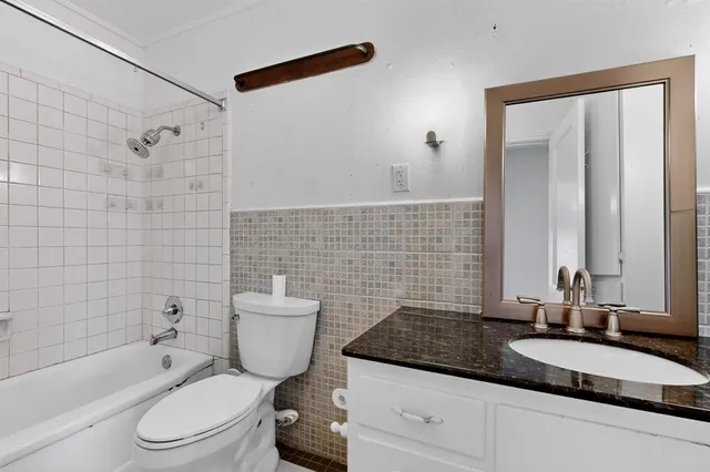 a bathroom with a granite countertop toilet a sink and bathtub