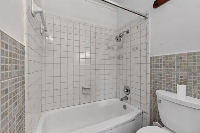 a bathroom with a toilet and bathtub