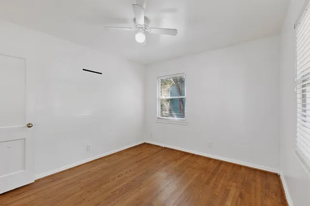 wooden floor in an empty room with a window