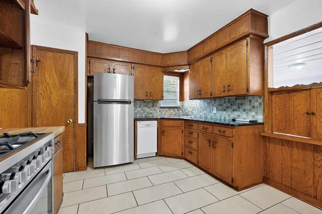 a kitchen with stainless steel appliances granite countertop a refrigerator and a stove