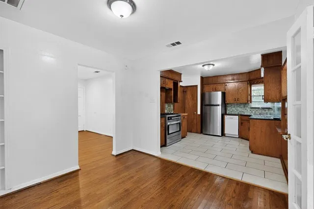 a kitchen with stainless steel appliances kitchen island granite countertop a refrigerator and a sink