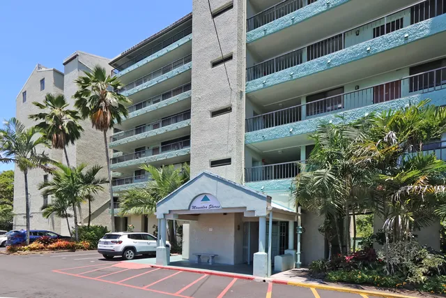a front view of a building with palm trees