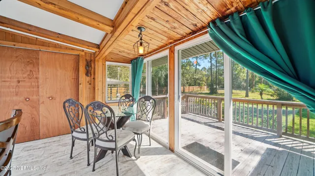 a view of a patio with table and chairs and wooden floor