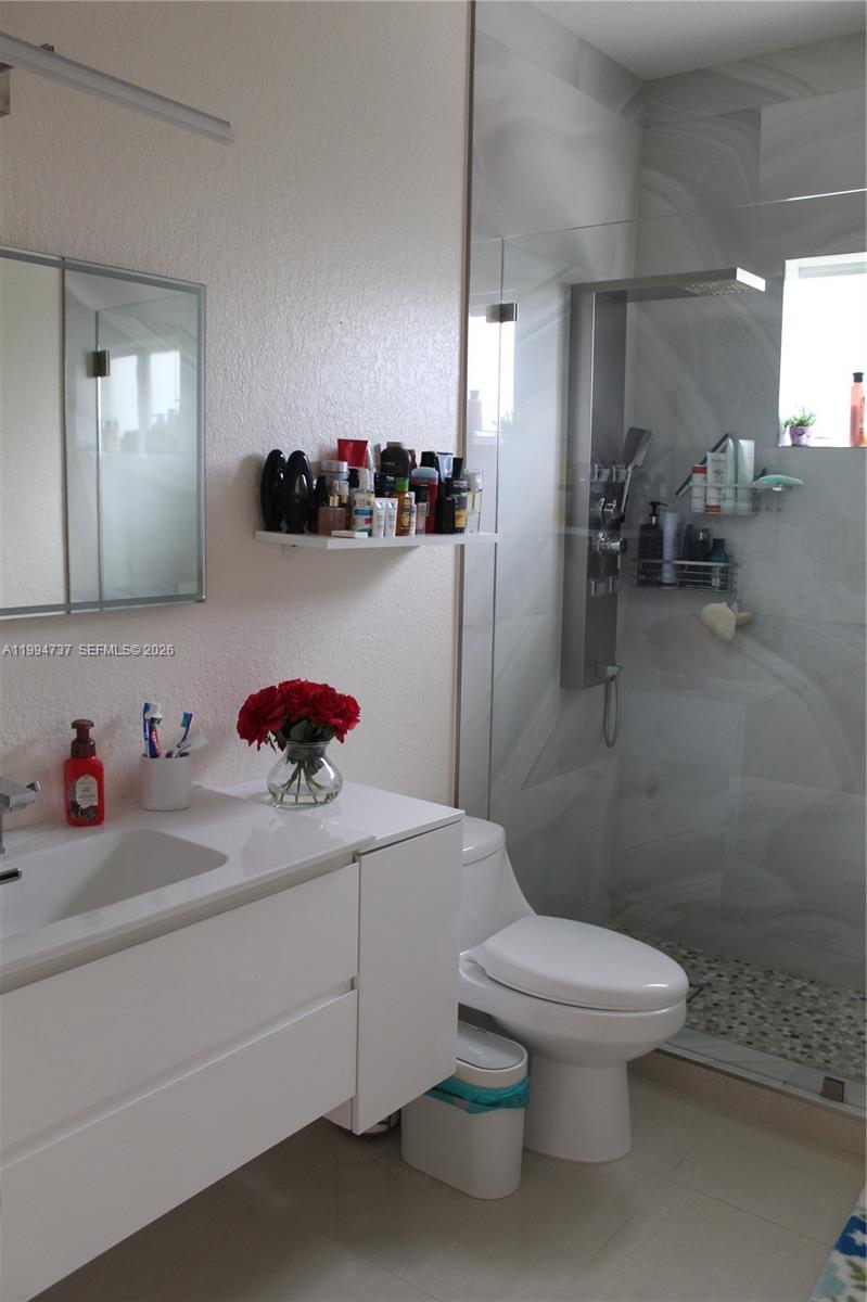 15580 Southwest 176th Terrace Miami, FL 33187 - Photo 22 of 32 a bathroom with a sink a toilet and a mirror