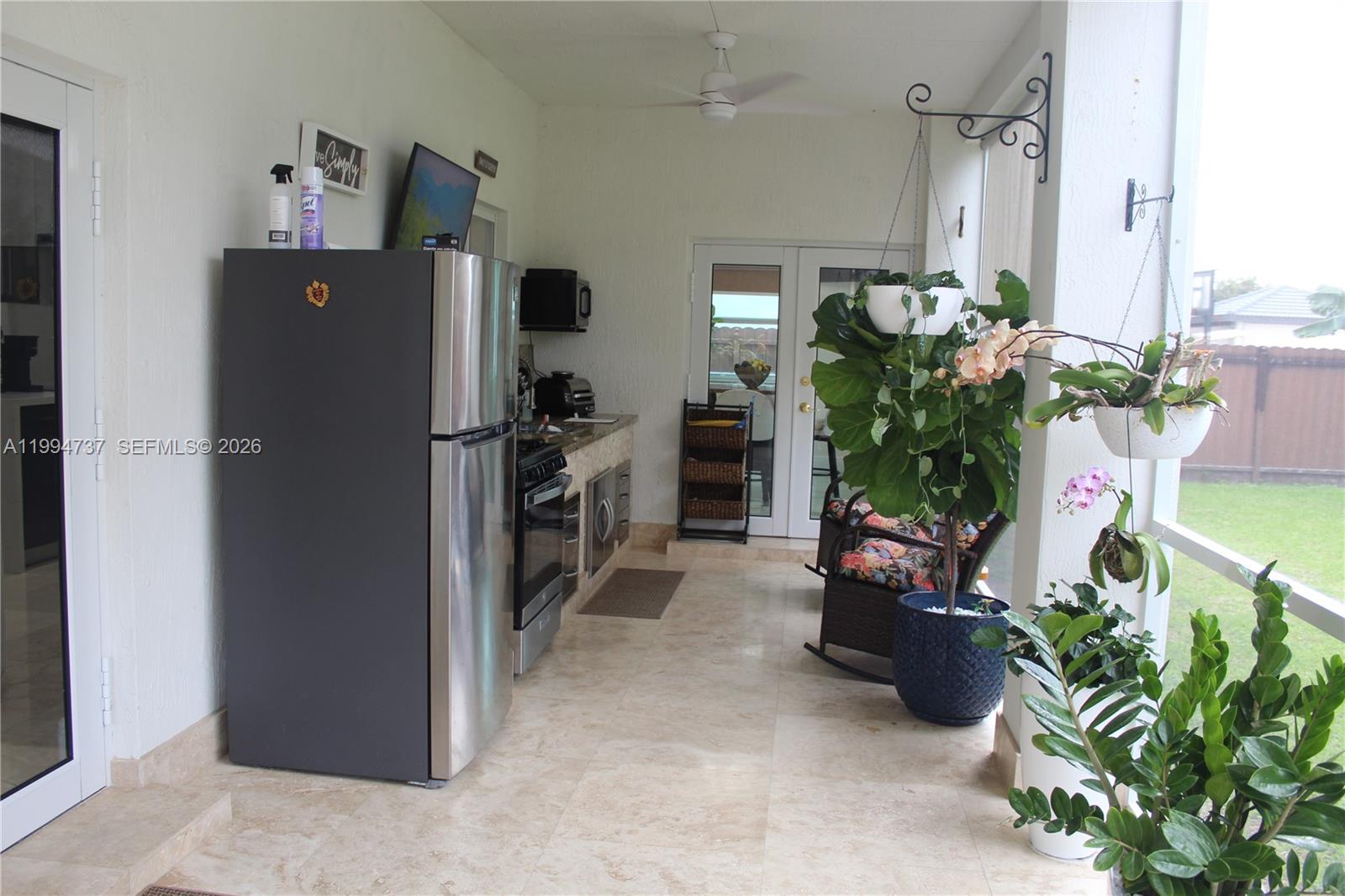 15580 Southwest 176th Terrace Miami, FL 33187 - Photo 29 of 32 a room with lots of potted plants and a refrigerator