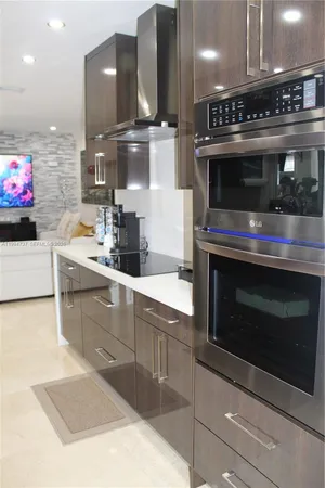 a kitchen with stainless steel appliances kitchen island granite countertop a stove and a sink