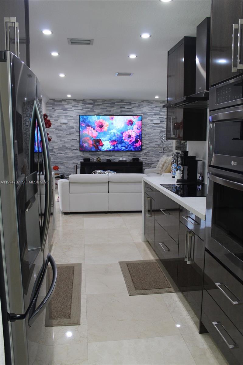 15580 Southwest 176th Terrace Miami, FL 33187 - Photo 10 of 32 a kitchen with stainless steel appliances granite countertop a sink stove and refrigerator