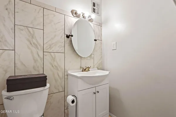 a bathroom with a sink a toilet and a mirror
