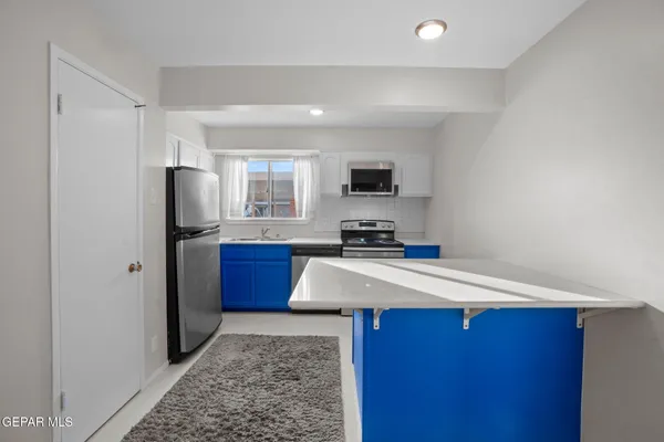 a kitchen with stainless steel appliances granite countertop a refrigerator stove and sink