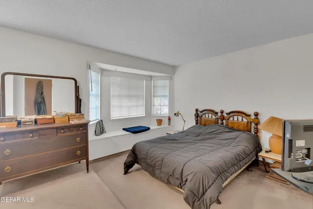 a bedroom with a bed and a large window