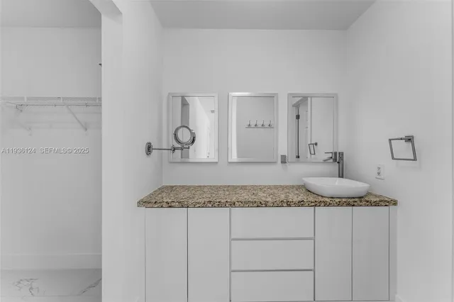 a bathroom with a granite countertop sink and mirror