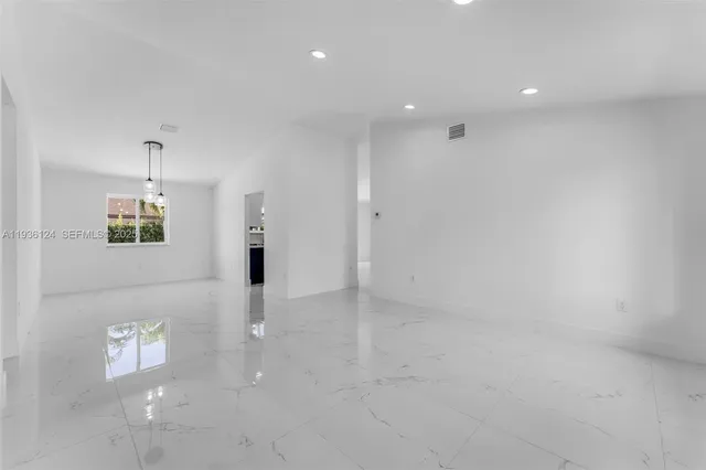 an empty room with white walls and windows