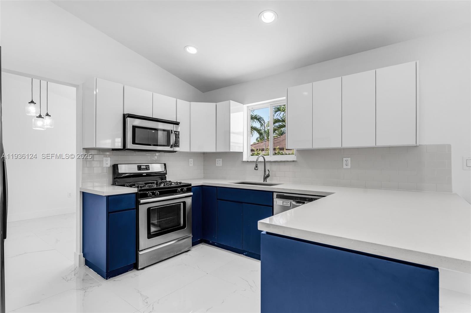 15042 Southwest 149th Court, Unit 1 Miami, FL 33196 - Photo 9 of 46 a kitchen with a sink stove top oven and microwave