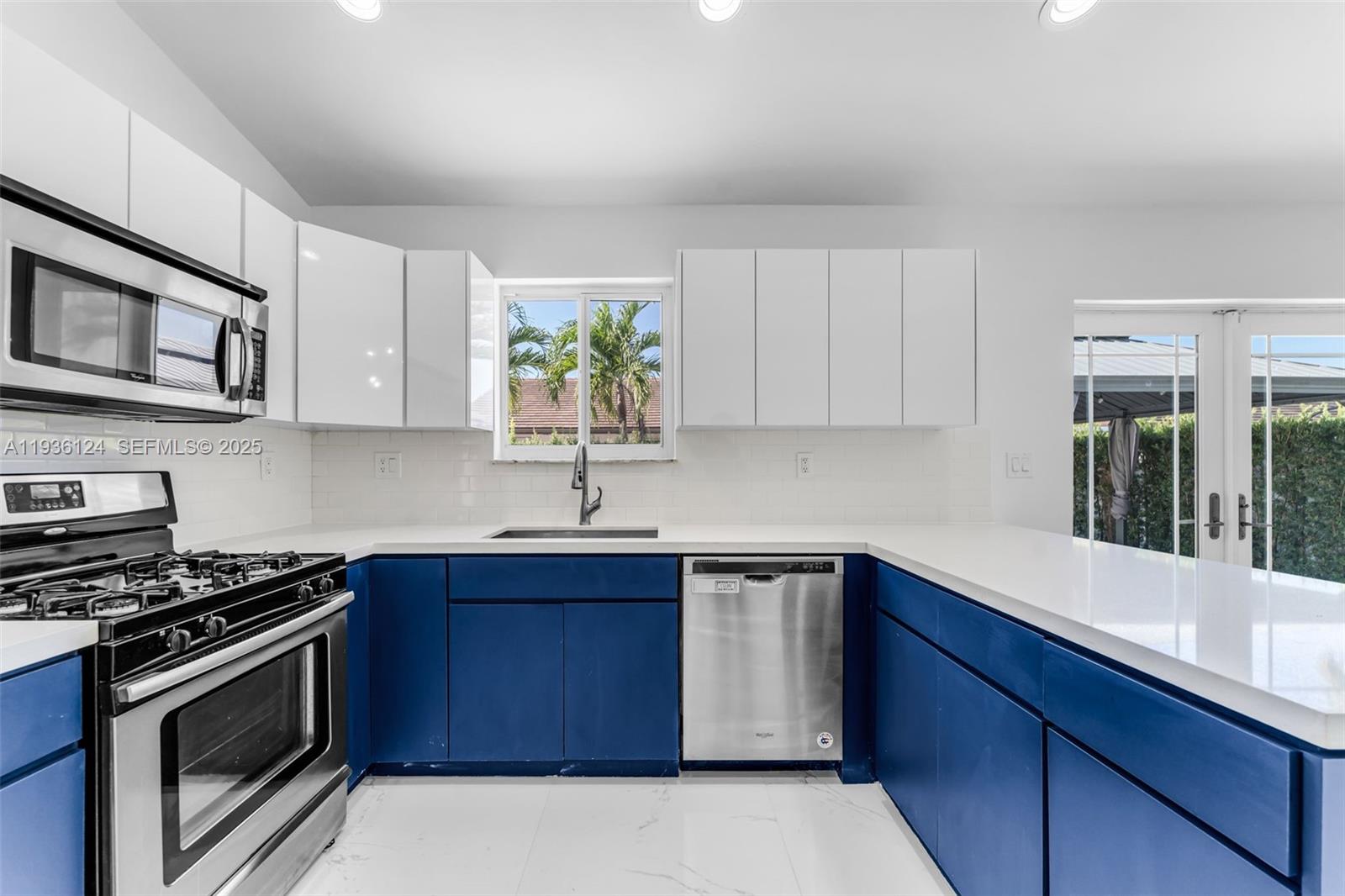 15042 Southwest 149th Court, Unit 1 Miami, FL 33196 - Photo 10 of 46 a kitchen with stainless steel appliances a stove a sink cabinets and a microwave