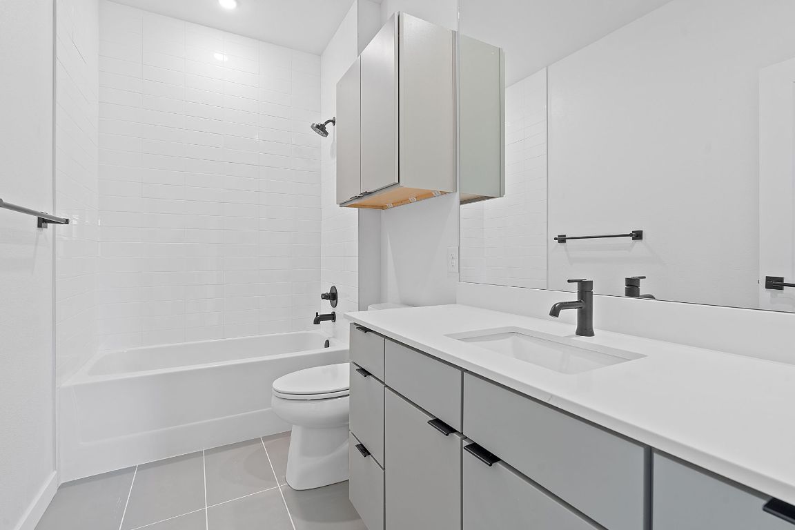 100 West Mockingbird Lane, Unit 307 Austin, TX 78745 - Photo 11 of 23 a bathroom with a sink a toilet and shower