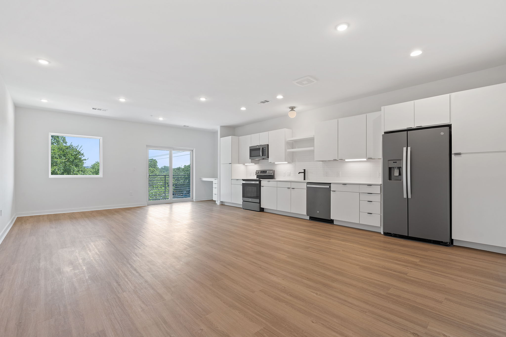 100 West Mockingbird Lane, Unit 307 Austin, TX 78745 - Photo 16 of 23 Kitchen featuring appliances with stainless steel finishes, light wood finished floors, light countertops, white cabinets, and recessed lighting