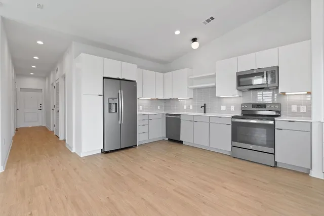 a kitchen with stainless steel appliances a refrigerator sink and microwave