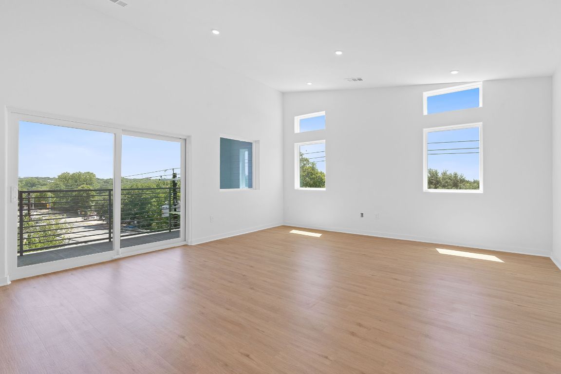 100 West Mockingbird Lane, Unit 307 Austin, TX 78745 - Photo 5 of 23 an empty room with wooden floor and windows