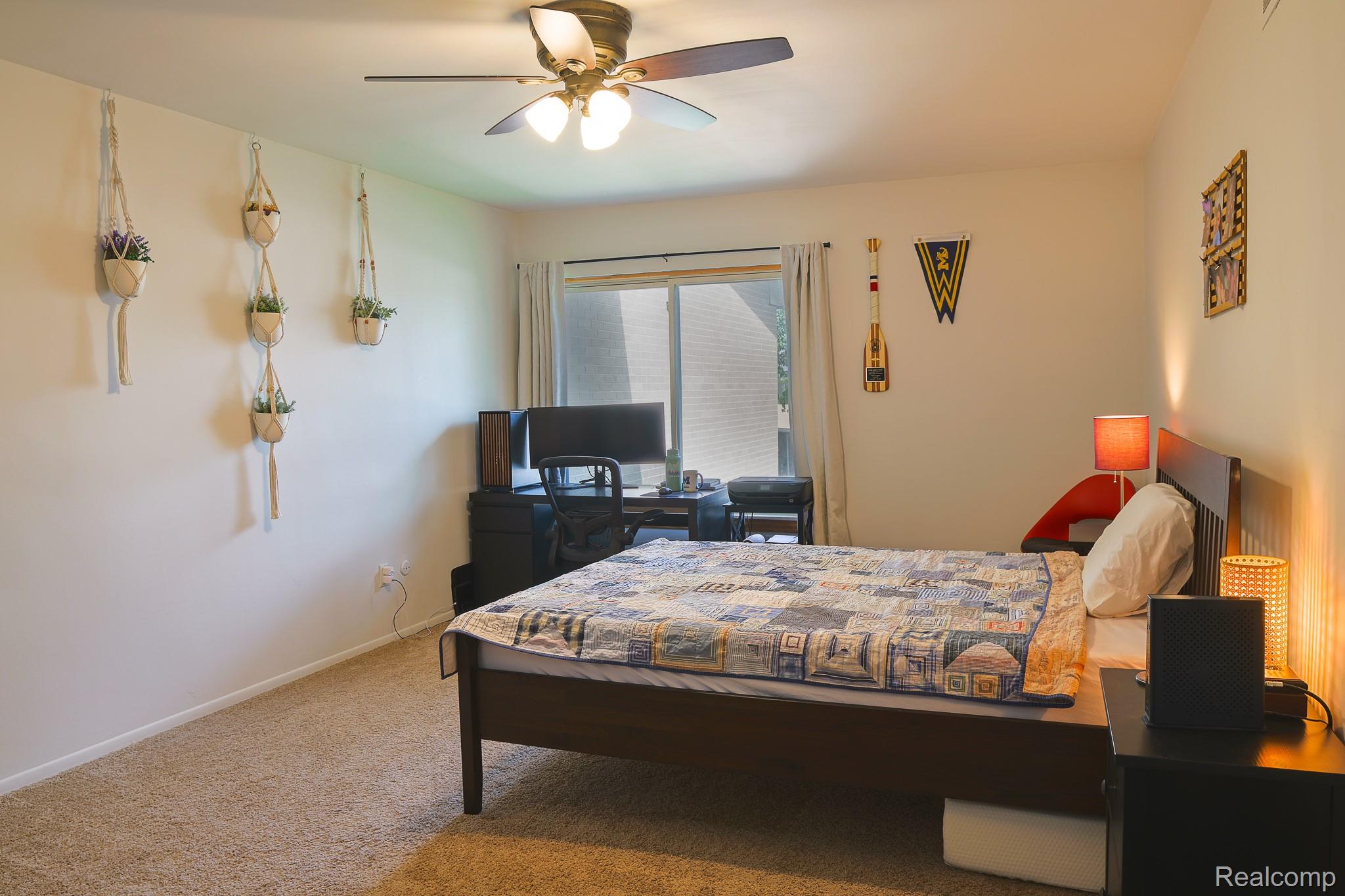 1989 Klingensmith Road, Unit 46 Bloomfield Hills, MI 48302 - Photo 25 of 41 Carpeted room featuring a ceiling fan with integrated lighting, a large window, and a built-in desk area