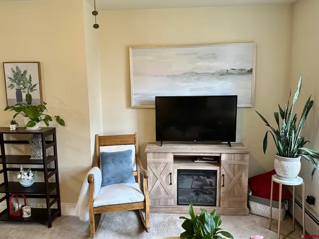 a living room with furniture a flat screen tv and a fireplace