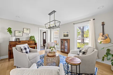 a living room with furniture a flat screen tv and a large window
