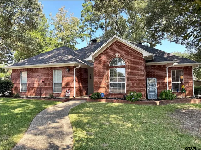 a front view of a house with a yard and trees