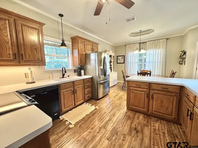 a large kitchen with kitchen island granite countertop a sink stainless steel appliances and cabinets