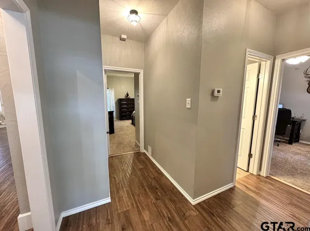 a view of a hallway with wooden floor and staircase
