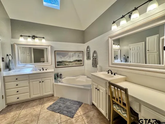 a bathroom with a granite countertop sink mirror and bathtub
