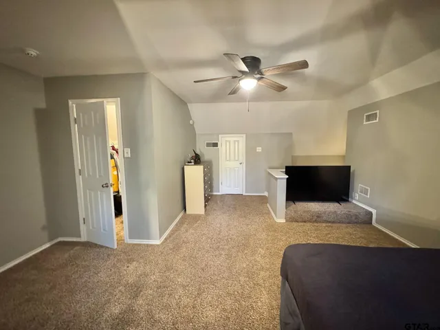 a living room with furniture and a ceiling fan
