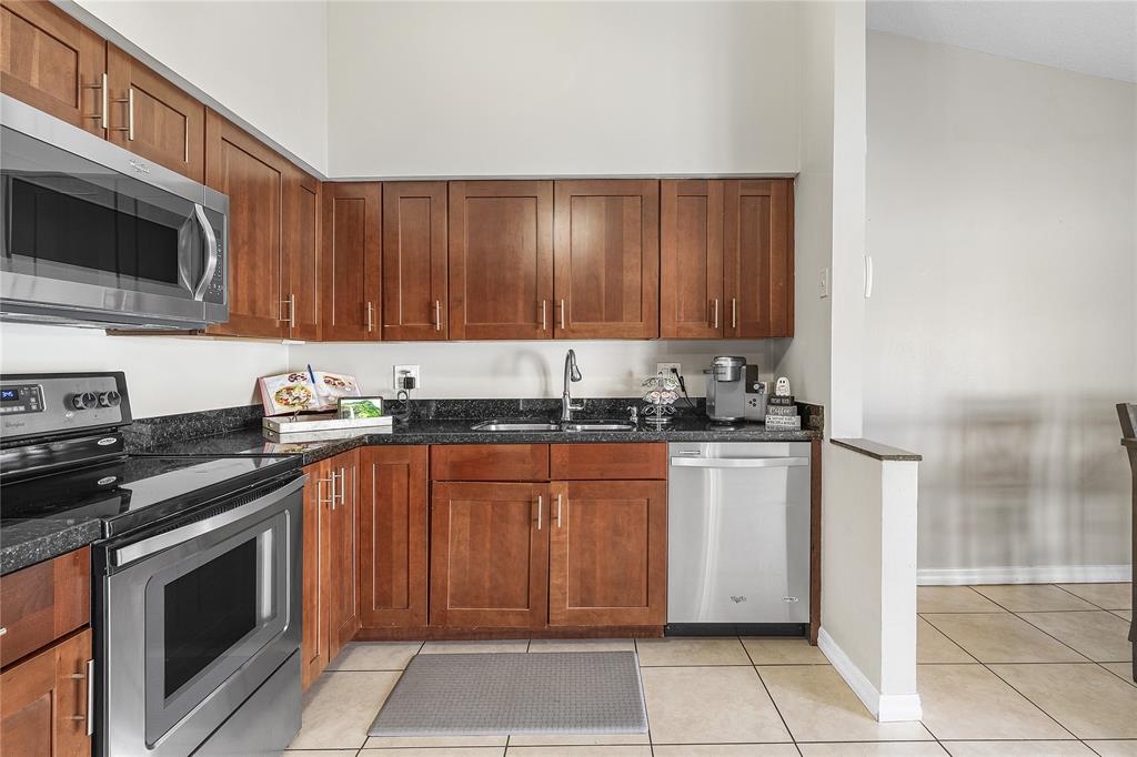 9661 Carousel Circle South Boca Raton, FL 33434 - Photo 8 of 25 a kitchen with stainless steel appliances granite countertop a stove a sink and a microwave