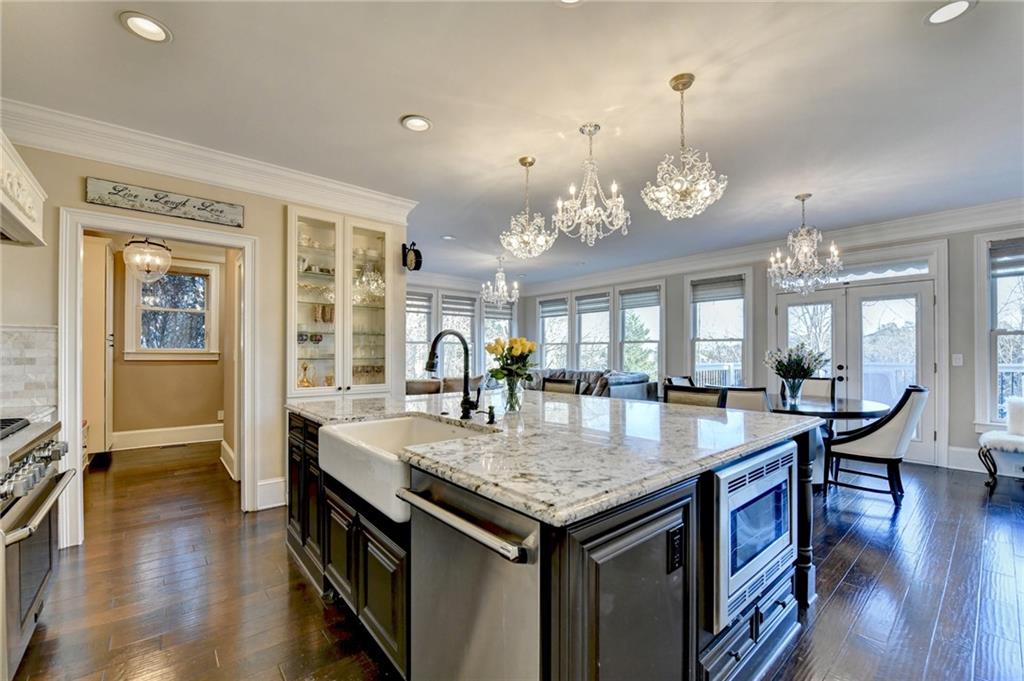 8360 Kenningston Way Duluth, GA 30097 - Photo 20 of 54 an open kitchen with granite countertop a stove and a wooden floor