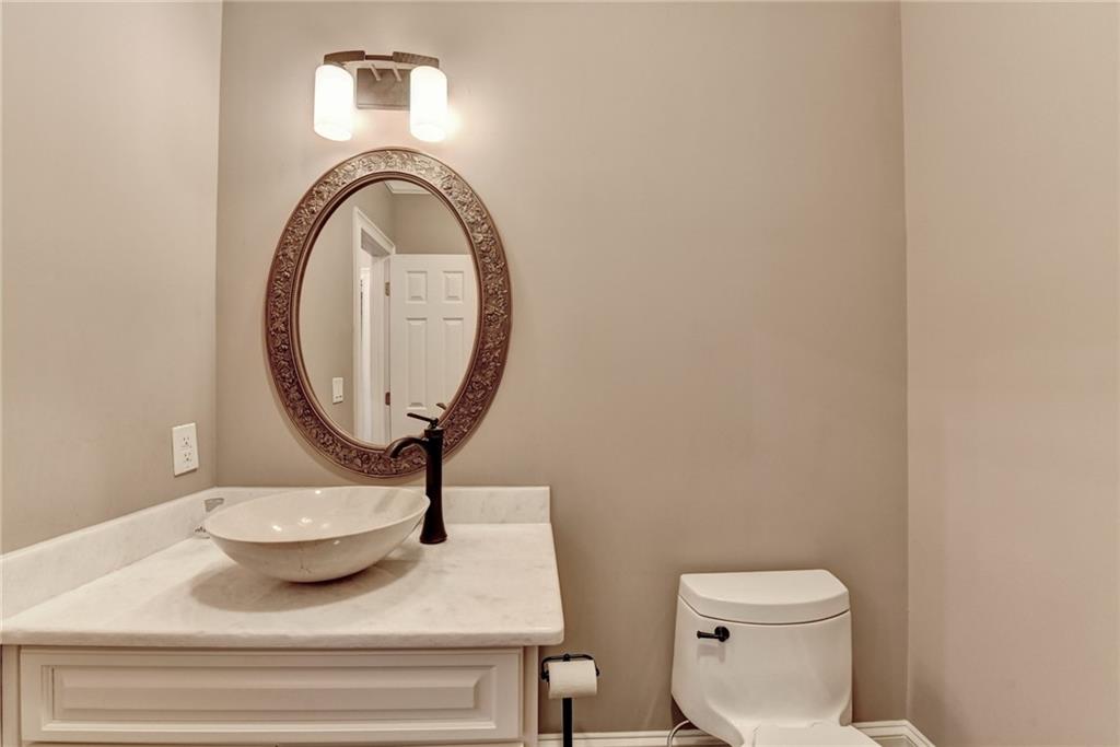 8360 Kenningston Way Duluth, GA 30097 - Photo 24 of 54 a bathroom with a toilet a sink and a mirror